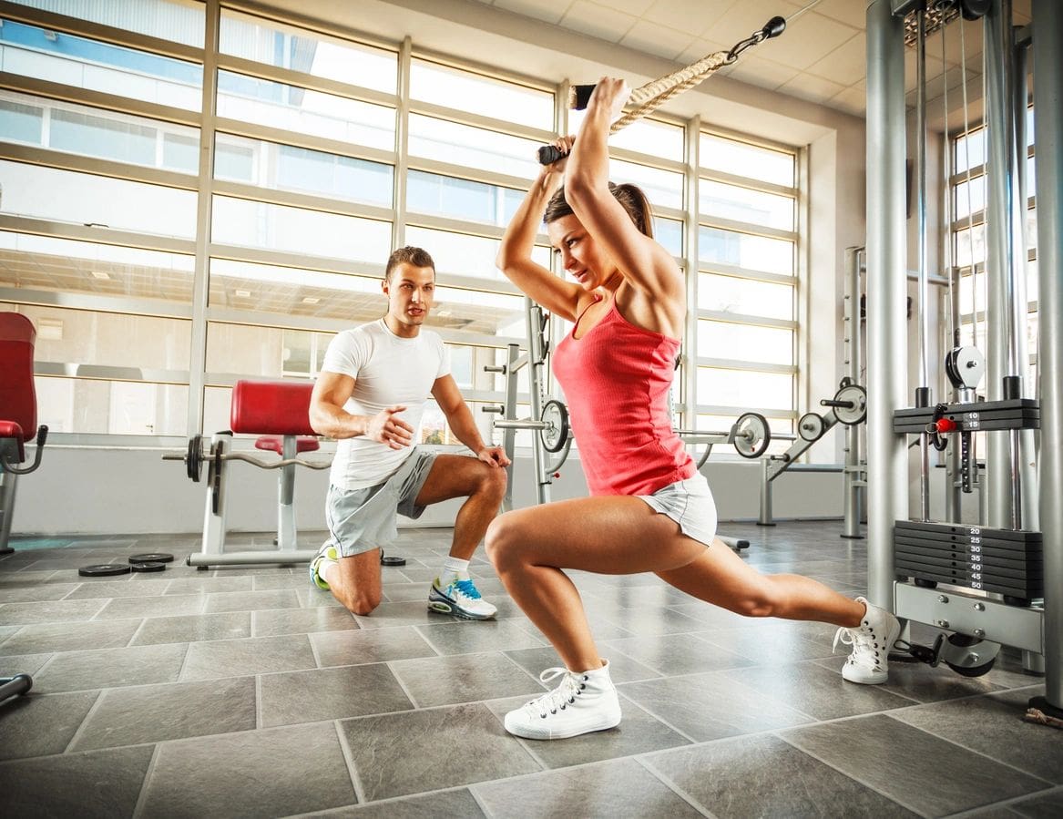 A woman is doing squats in the gym